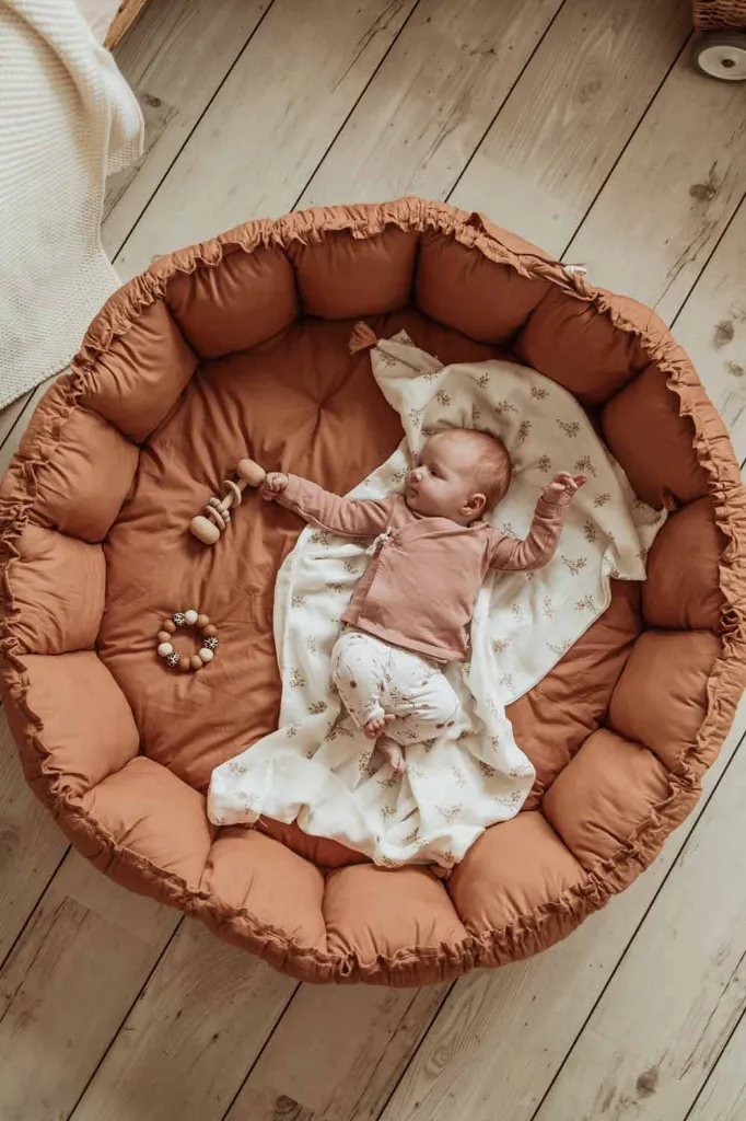 PlayandGo_organic_babymat_Bloom_tawny_brown_picture_from_above_little_baby_lying_on_mat (1).webp